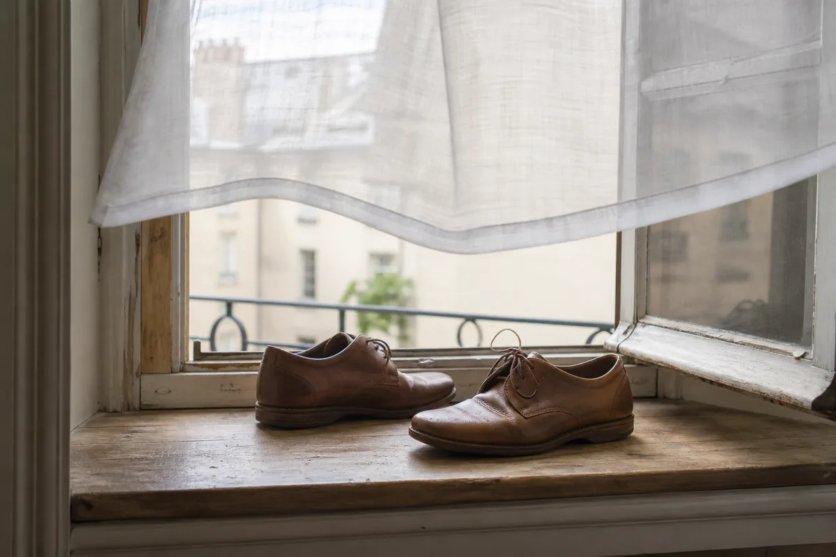 Chaussures en cuir posées près d’une fenêtre ouverte pour aérer